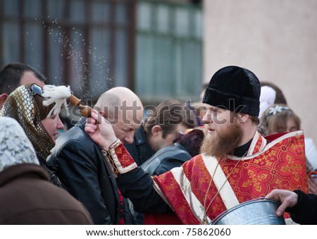 DONETSK, UKRAINE - APRIL 24: An unidentified Orthodox priest spatter the holy water on Easter cakes at the celebration of Orthodox Easter at church on April 24, 2011 in Donetsk, Ukraine.