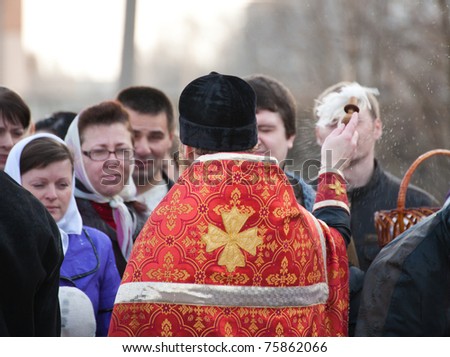DONETSK, UKRAINE - APRIL 24: An unidentified  Orthodox priest spatter the holy water on Easter cakes at the celebration of Orthodox Easter at church on April 24, 2011 in Donetsk, Ukraine.