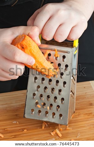 Hand holding carrot vegetable food kitchen grater