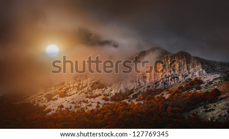 Mountain in the clouds at sunset
