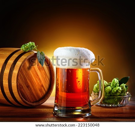 Beer barrel with beer glass on a wooden table. The dark background.