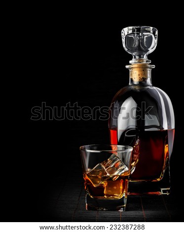 Studio shot of whiskey in a carafe and glass isolated on black