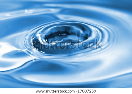 Extreme closeup of water ripples just formed by the impact of water drops. Focus at the center with very shallow depth of field.