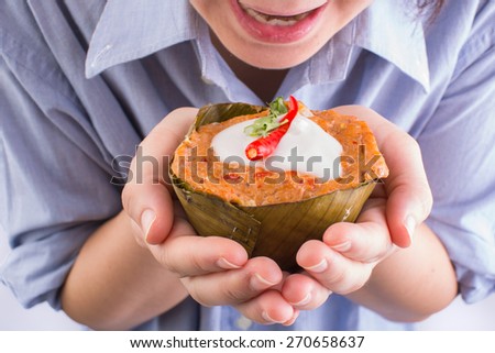 thai food, steamed fish curry custard in banana leaf on hand on white background