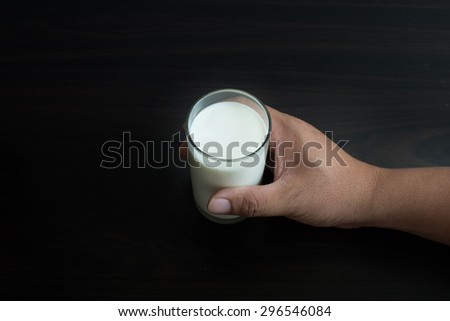 hand hold milk  on wood background lowkey style