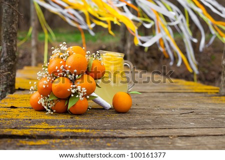 Stylized Brides Bouquet made ??out of oranges lying on the bridge. Photo in the park on the lake.