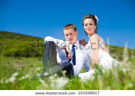 Couple in love bride and groom enjoy a moment of happiness in the daisy field. The wedding day in the spring.