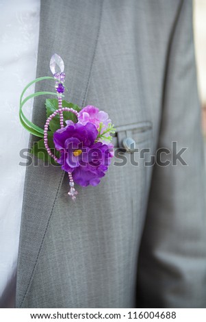 The groom at a wedding ceremony. Boutonniere for gray jacket.