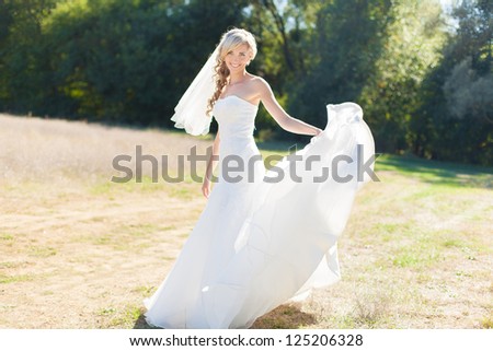 Portrait of beautiful blond bride in action. Wedding dress.
