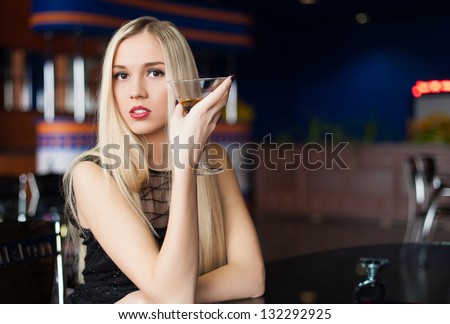 Happy young women drinking a glass of alcoholic beverage at restaurant or club