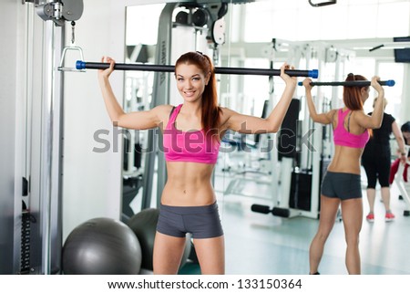 Attractive young fitness model exercising in fitness sport club