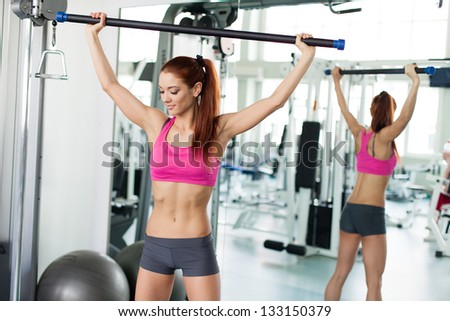 Attractive young fitness model exercising in fitness sport club