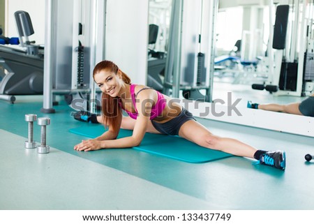 Attractive young fitness model exercising in the gym