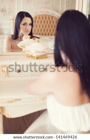 beautiful young woman in the mirror in the bedroom