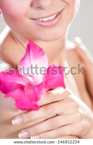 Beautiful Model Woman Face With Pink Flowers In Hair. Perfect Skin. Professional Make-up. Beauty and spa concept
