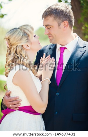 Beautiful wedding couple hugging. Bride and groom celebrating their wedding day in summer