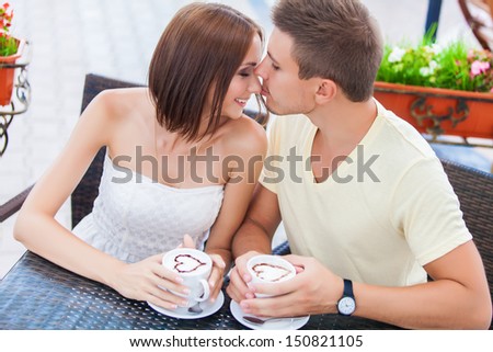 Happy couple in love drinking coffee and looking at each other