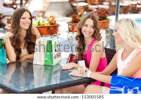 Beautiful Young Women Friends In Cafe On A Terrace After The Shopping