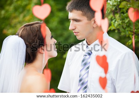 young wedding couple, beautiful bride with groom portrait over garland of hearts