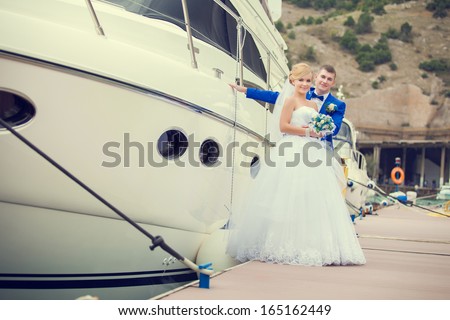Beautiful bride and groom wedding couple near sea yacht. Happy newlywed couple at wedding. Cheerful married couple standing on the beach. Monaco wedding. Cote de azure Gorgeous wedding outdoor