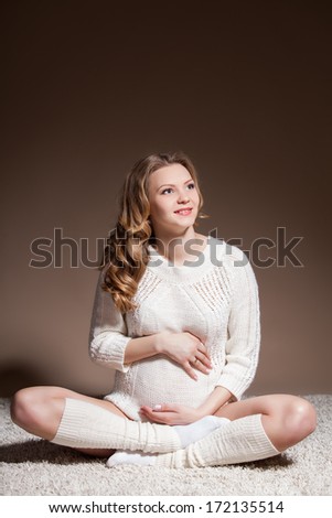 Beautiful pregnant woman wearing woolen accessories