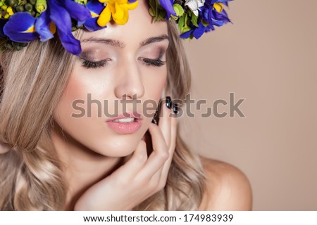 Young woman posing with her eyes shut and flowers in her hair