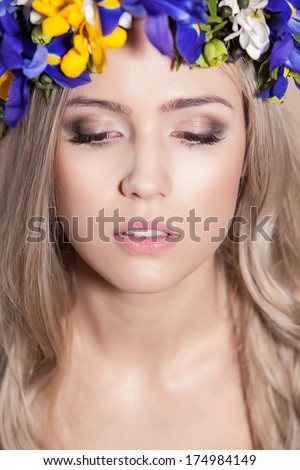 Young woman posing with her eyes shut and flowers in her hair