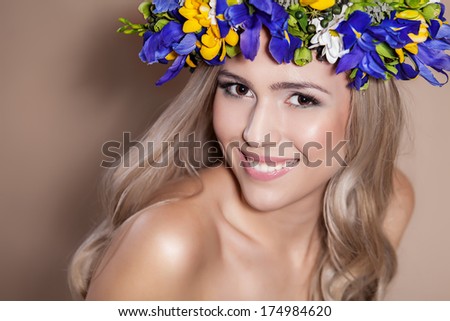 Young woman with a flower arrangement in her hair smiling at the camera