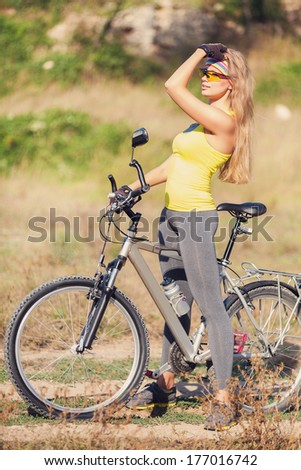 Portrait of excited young smiling woman cycling in the park