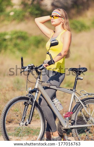 Portrait of excited young smiling woman cycling in the park