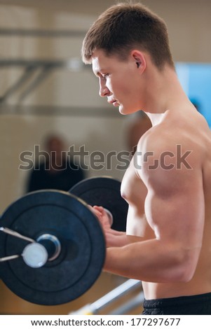 Profile of a young man working out in the gym