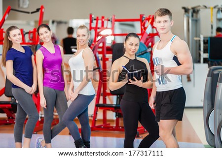 Group of young sport people in gym. Gym and Fitness. Smiling people.
