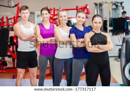 Group of young sport people in gym. Gym and Fitness. Smiling people.