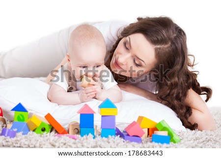 mother and baby playing with building blocks toy over white
