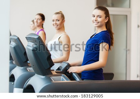 young sporty women run on machine in the gym centre