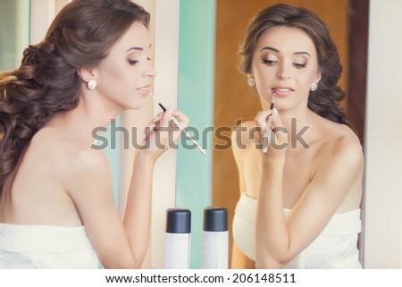 Beautiful brunette bride with wedding makeup and hairstyle, attractive newlywed woman have final preparation for wedding. Bride makeup.