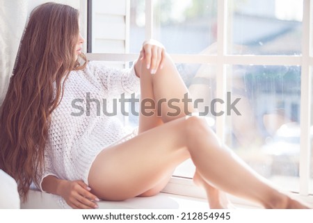 Beautiful lady sitting by the window indoor