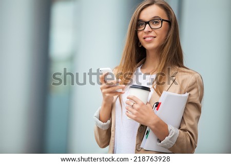 Successful businesswoman with cellphone while walking outdoor. City business woman working.