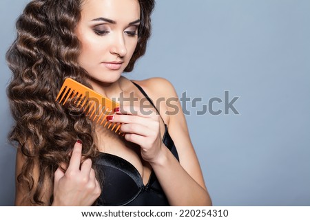 Woman Portrait. Curly Hair and Comb in studio