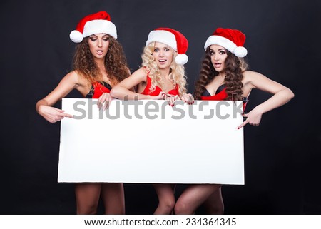 Group of cheerful santa girls hold the blank placard with copy text. Christmas greetings card
