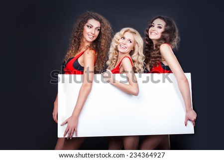 Cheerful sexy girls hold the blank placard with copy text. Greeting card