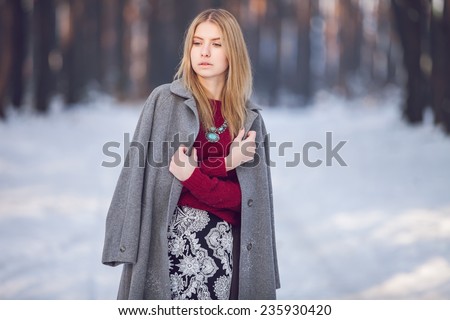 Young beautiful model posing in winter forest. stylish fashion portrait