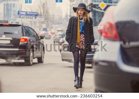 fashionable young woman posing outside in a city street
