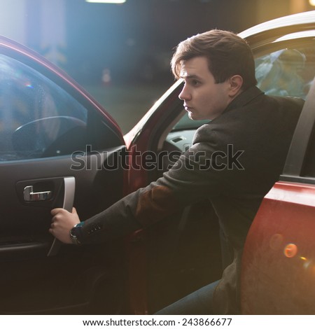 Portrait of an handsome business man with his car