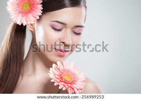 Skincare of young beautiful woman face with fresh flower