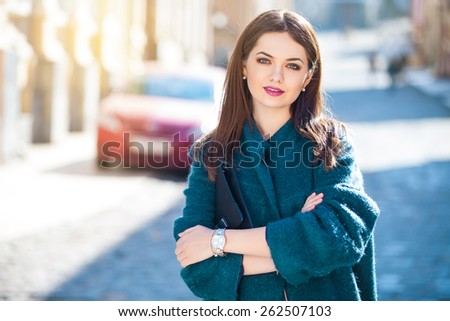 Day dreaming pretty brunette posing outdoors on urban background