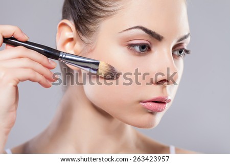 Beauty girl with makeup brushes. Perfect smooth skin.Applying makeup.Beautiful young woman holding different make up brushes