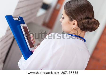 Female doctor looking at medical records on tablet computer at hospital