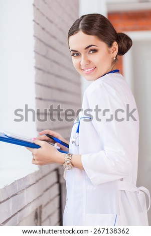 Female doctor looking at medical records on tablet computer at hospital
