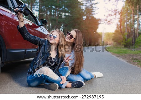 Happy friends on road trip taking selfie on a summers day. Little holiday trip